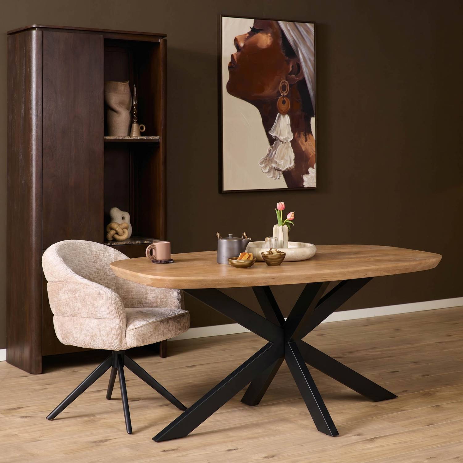 Ovaler Esstisch aus Mangoholz mit schwarzem Spinnengestell im modern eingerichteten Esszimmer – Kojas