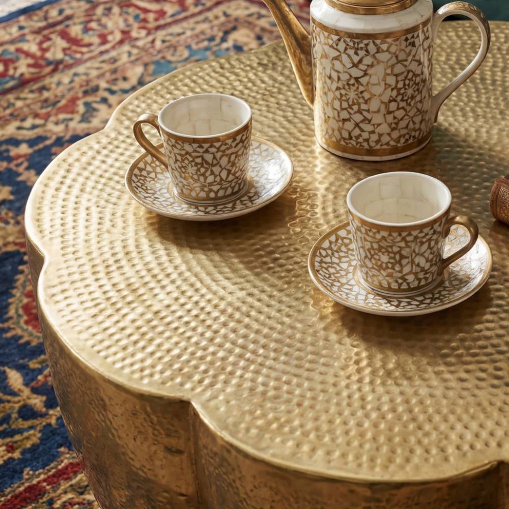 Gehämmert goldener Couchtisch mit strukturierter Oberfläche und Tassen – Gracia