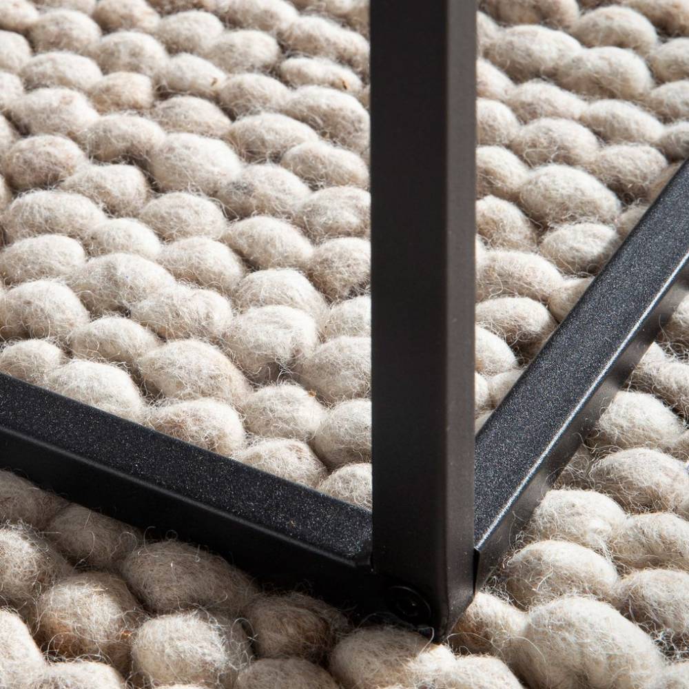 Schwarzes Metallgestell des Wohnzimmer Tisches in Betonoptik auf einem strukturierten Teppich – Libonato