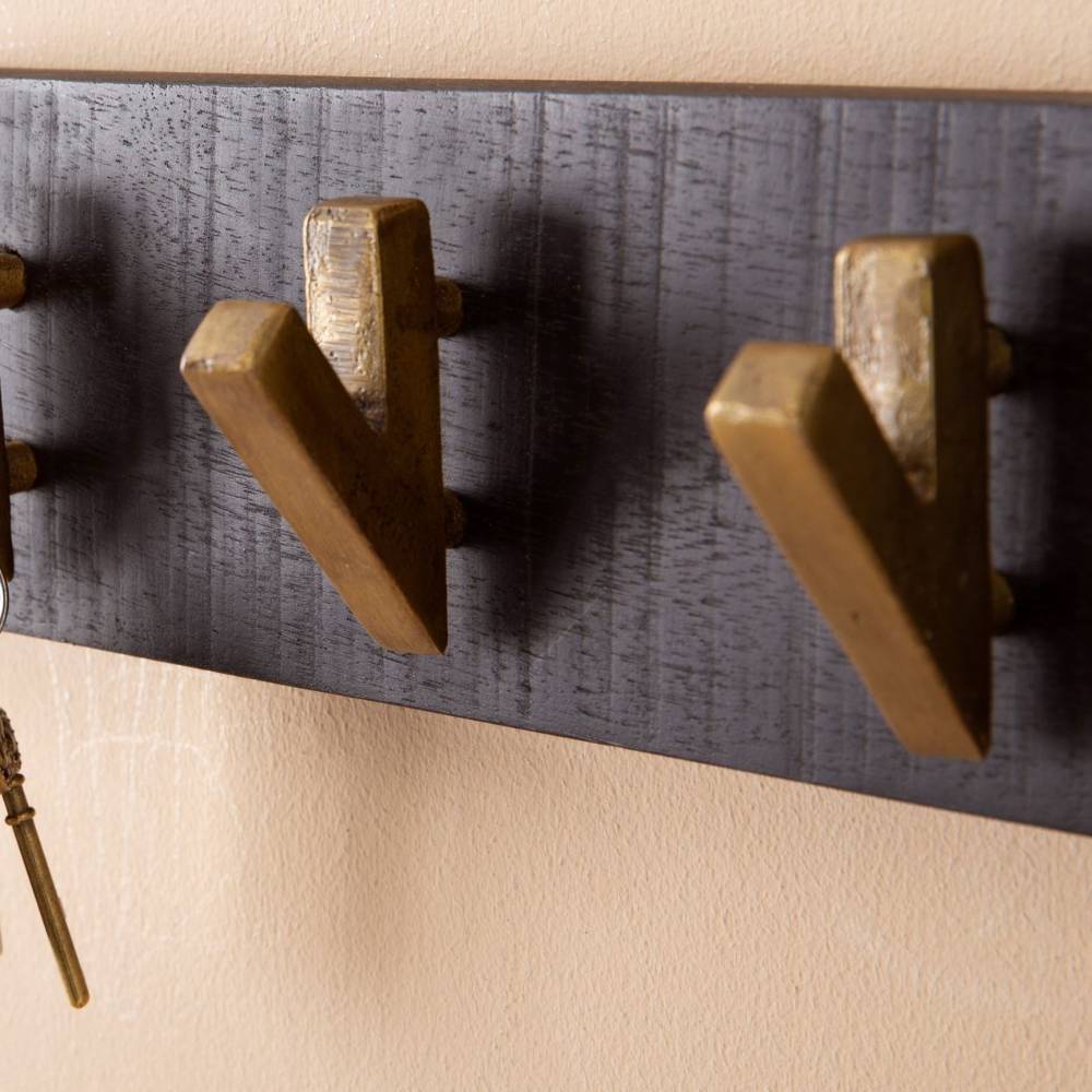 Messinghaken einer schwarzen Hakenleiste aus Holz für die Wandgarderobe im Detail – Baonga