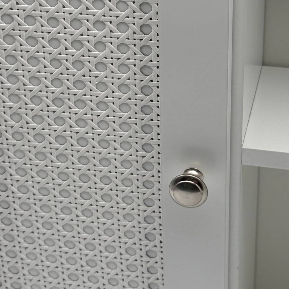 Detailansicht der weißen Schranktür mit dekorativem Rattan-Geflechtmuster – Uniaka