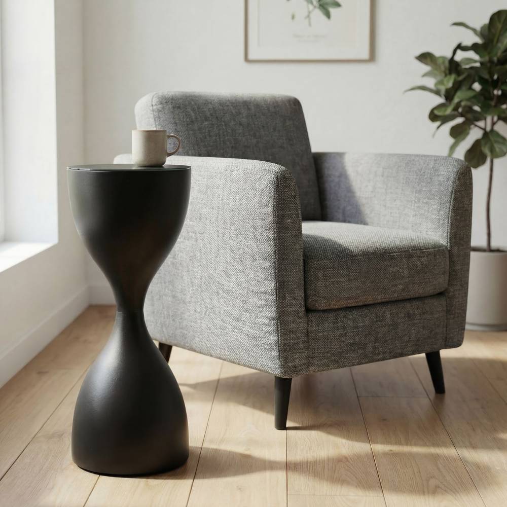 Moderner schwarzer Beistelltisch im Sanduhr Design neben Sessel im Wohnzimmer – Yohana