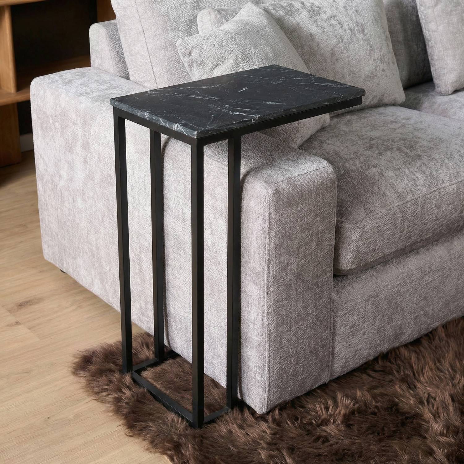 Unterfahrbarer Beistelltisch mit dunkler Marmorplatte am Sofa im Wohnzimmer – Rikera