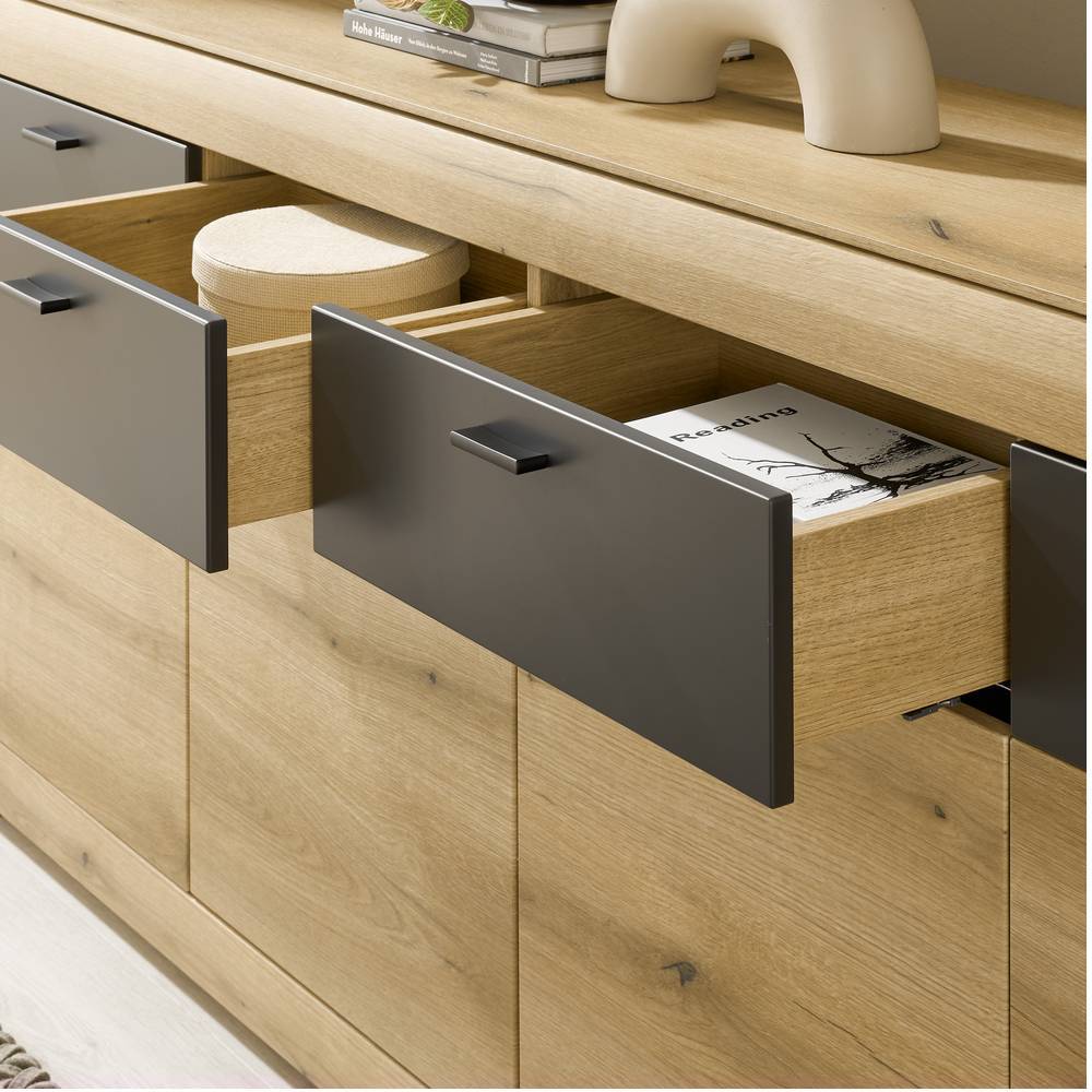 Zwei geöffnete Schubladen des Sideboards in Eichenholzoptik mit dunklen Fronten – Addara