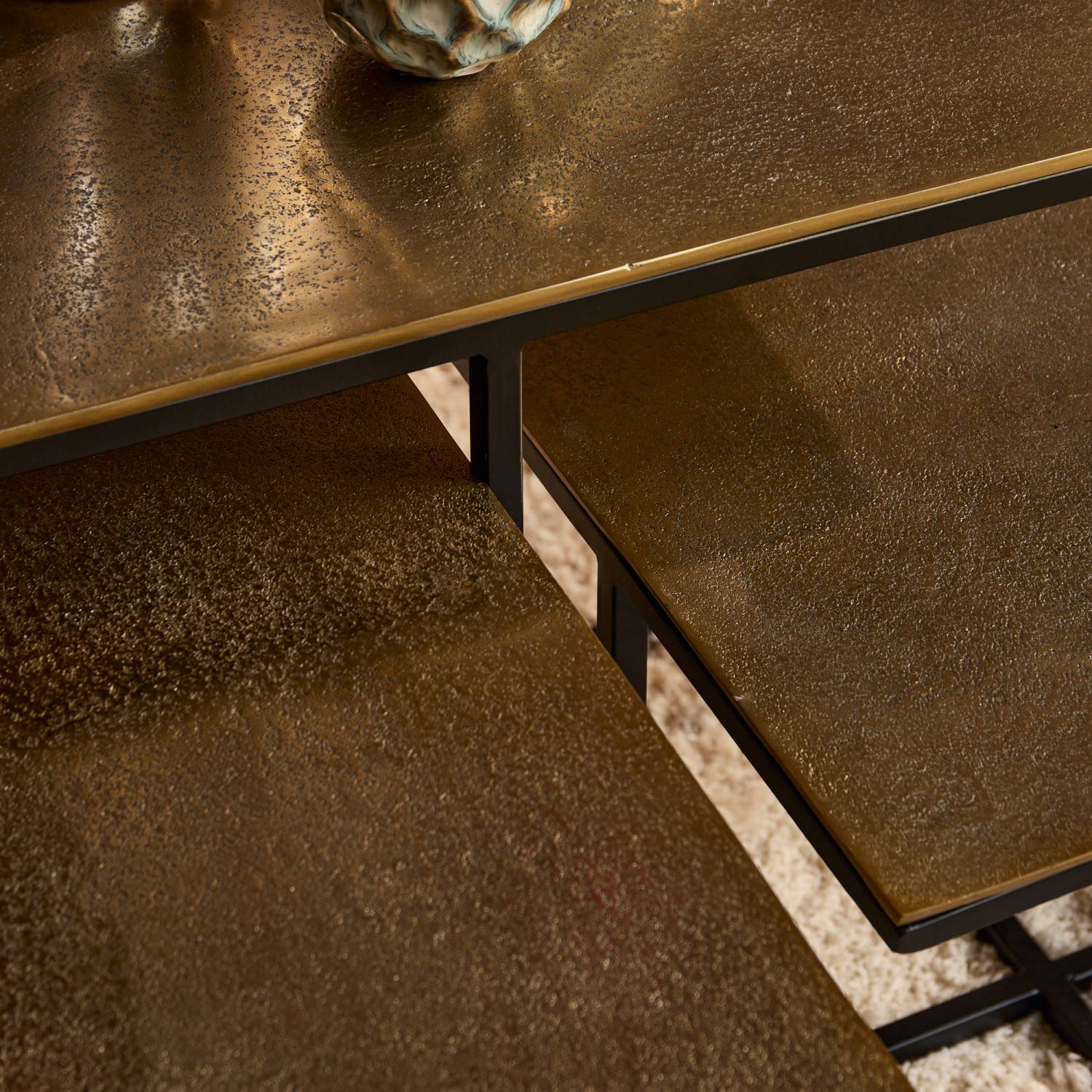 Mehrstufiger Metall Couchtisch mit detaillierter Bronze-Optik Oberfläche und schwarzem Gestell – Maragas
