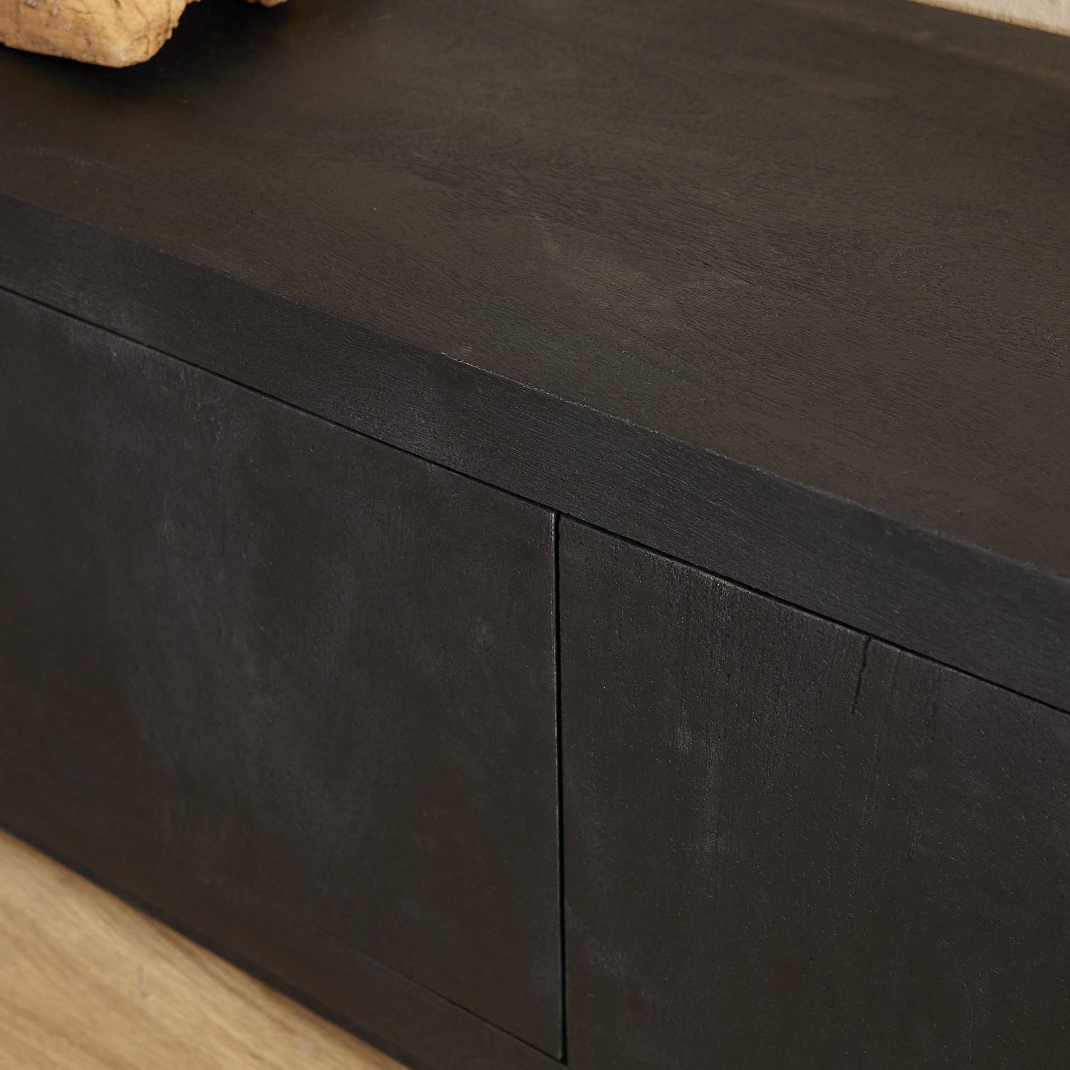 Schwarze Holzoberfläche des TV Boards mit feinen Türspalten – Trapper