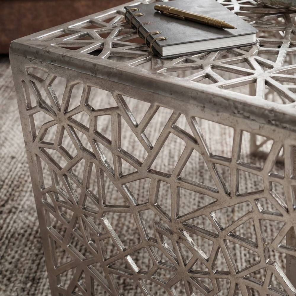 Silberfarbener Design-Beistelltisch mit filigranem geometrischem Muster auf Teppichboden \u2013 Viamo