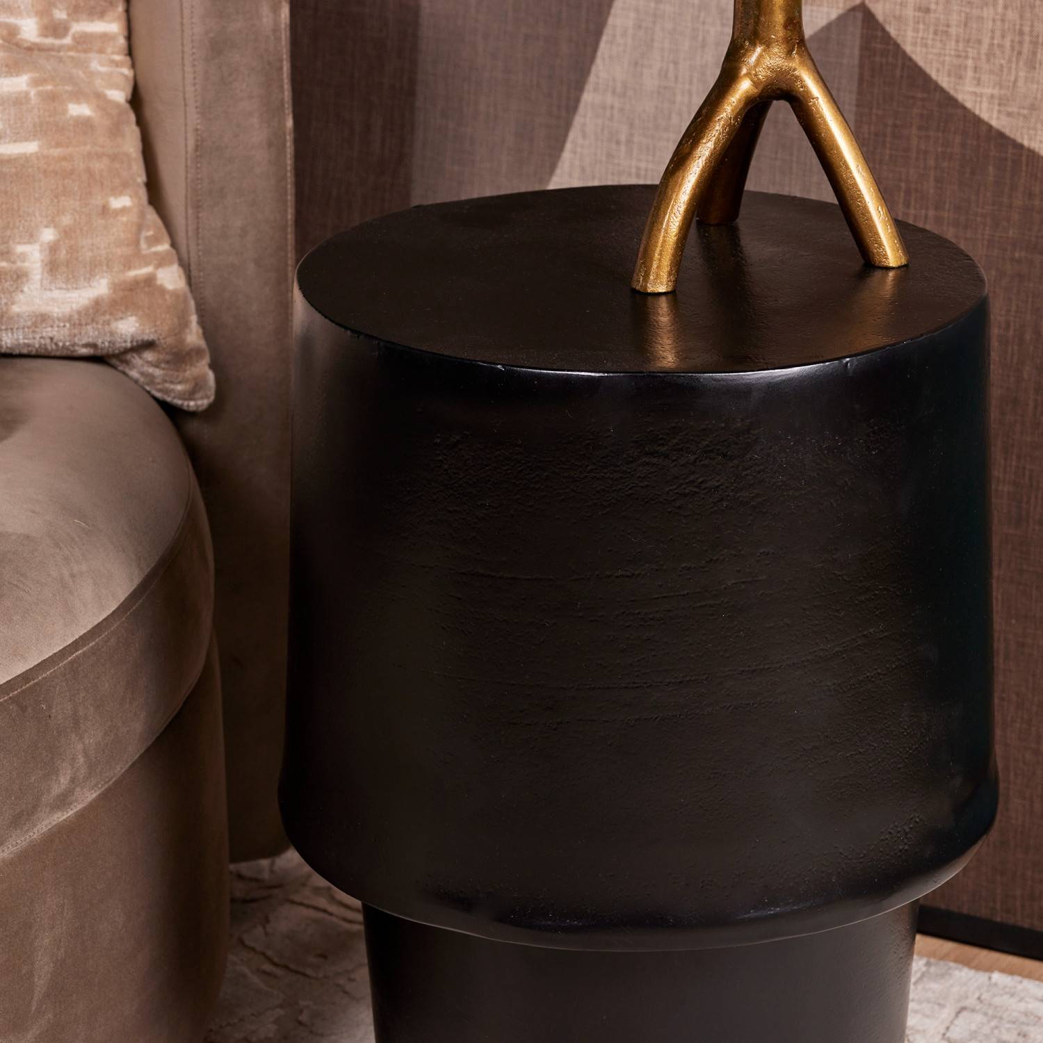 Trommelförmiger Designtisch schwarzes Metall im Wohnzimmer neben hellem Sofa – Blando