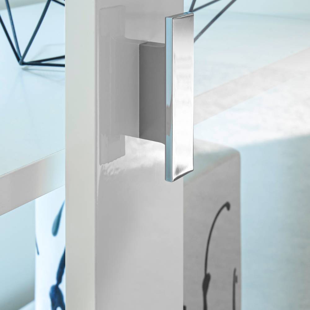 Moderner, glänzender Griff aus Chrom an der weißen Schiebetür des Highboards – Memphys