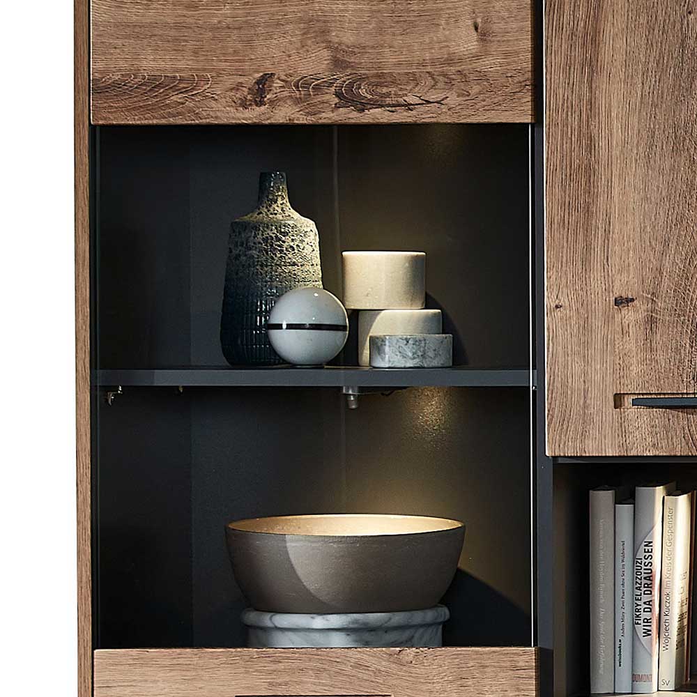 Beleuchtetes offenes Fach der Wohnzimmer-Vitrine mit Glasablage und dunkler Rückwand – Xindus