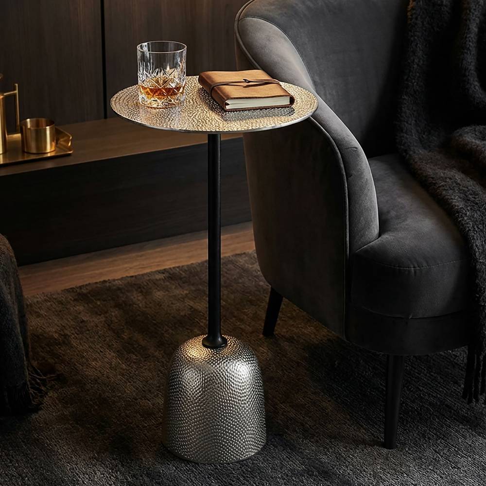 Runder Beistelltisch aus Metall mit Perlstruktur neben Sessel im modernen Wohnzimmer – Valtte