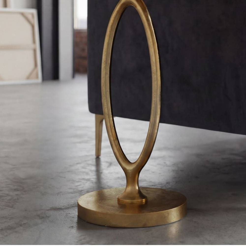 Goldener Aluminium Beistelltisch mit ovalem Standfuß auf Betonboden – Daroncas