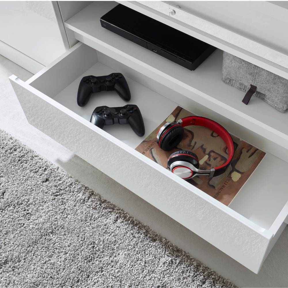 Ausgezogene Schublade des weißen TV-Lowboards mit Gaming-Controllern und Kopfhörern – Memphys