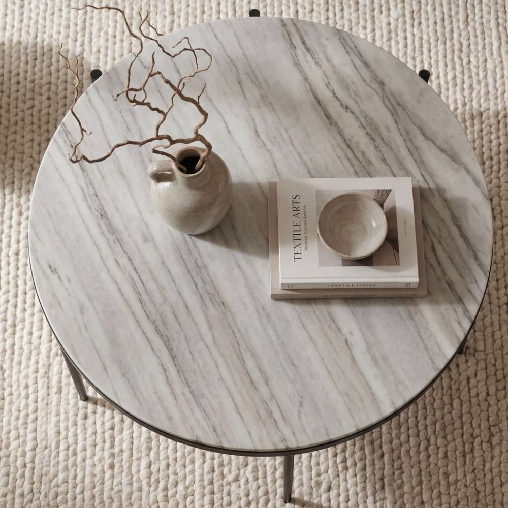 Runder Couchtisch mit heller Marmorplatte und schlanken schwarzen Metallbeinen – Cubana