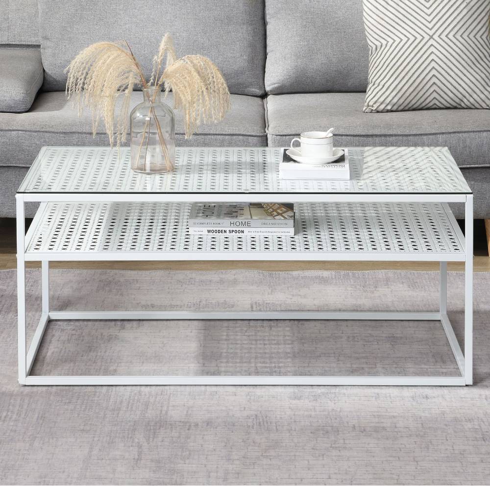 Weißer Couchtisch mit Glasplatte und gelochter Metallablage im Wohnzimmer – Marian