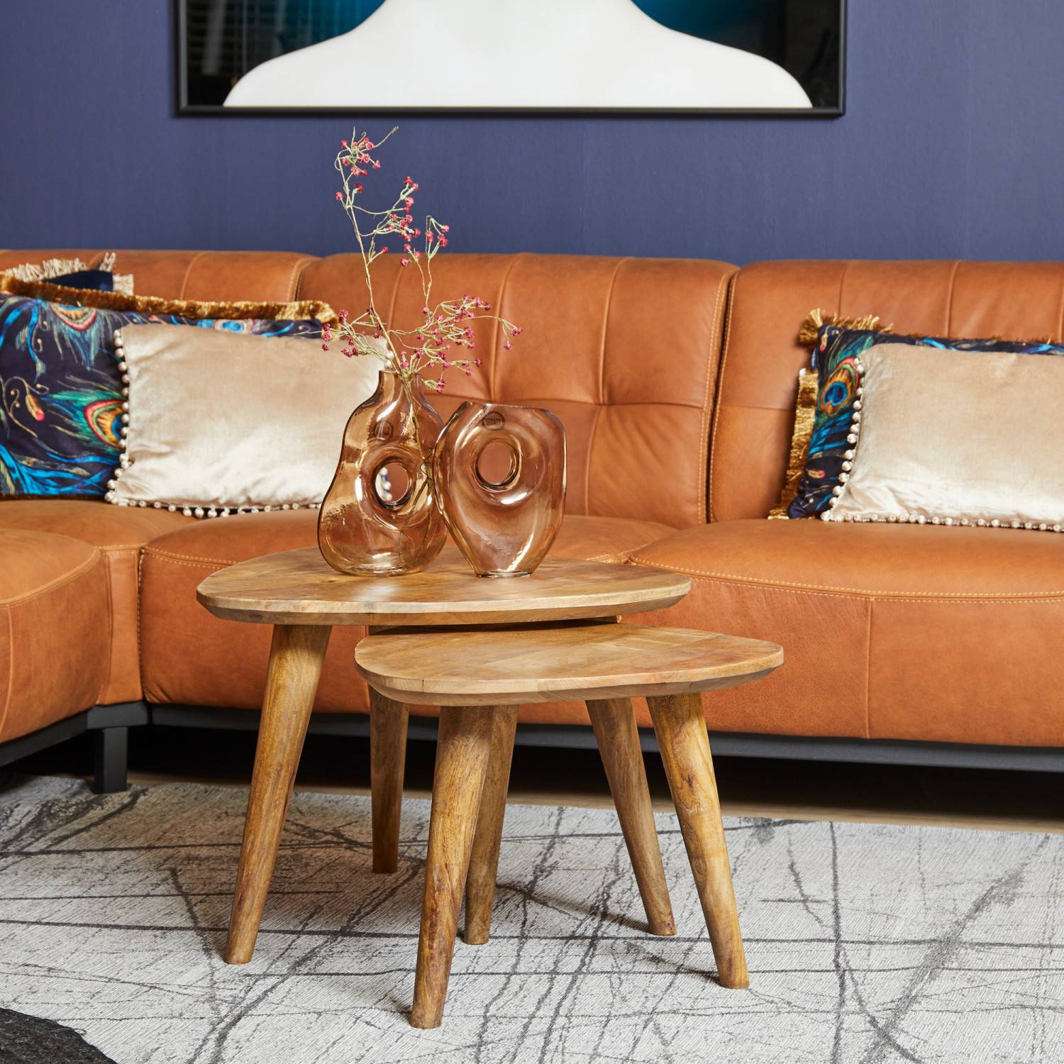 2er Set Couchtische aus Mangoholz mit dreieckigen Platten vor einem Ledersofa – Tenerife