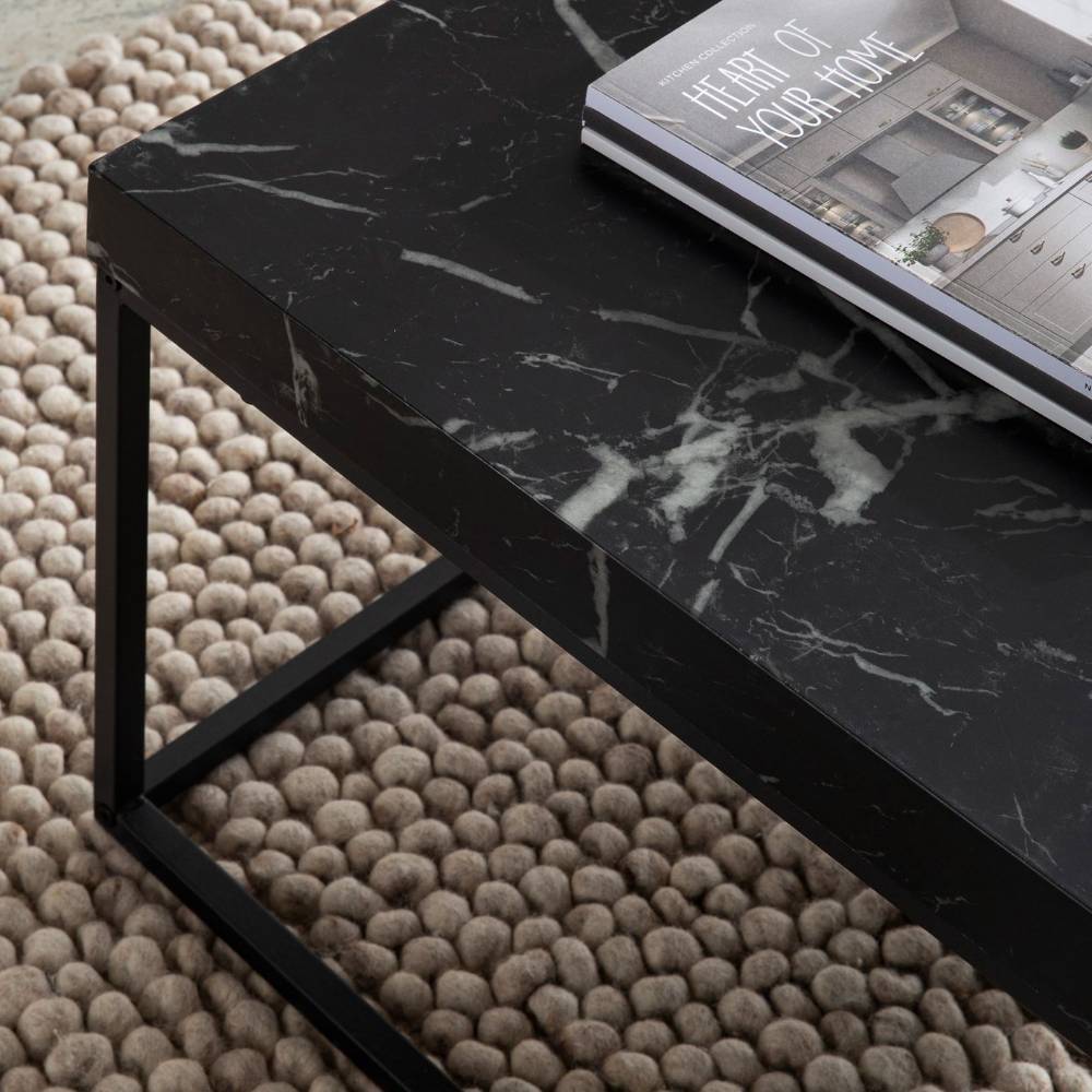 Schwarzer Couchtisch in Marmoroptik mit elegantem Metallgestell auf einem Teppich – Novo