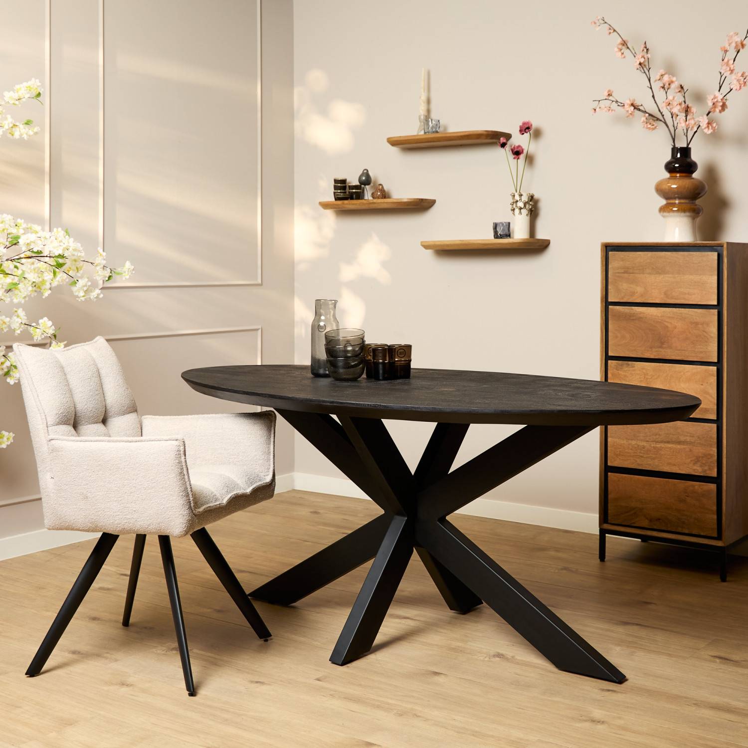 Schwarzer ovaler Designtisch im Esszimmer mit beigem Stuhl und Holzelementen – Krems