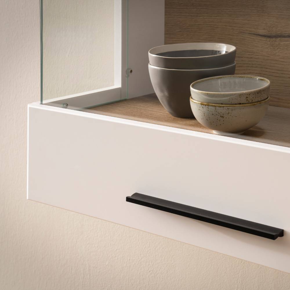 Detail der Hängevitrine in Weiß mit schwarzem Griff und geöffnetem Fach – Acke