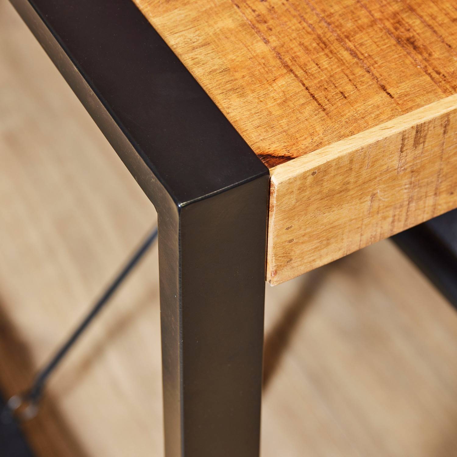 Holzmaserung der Tischplatte und robuste schwarze Metallbeine – Ceria