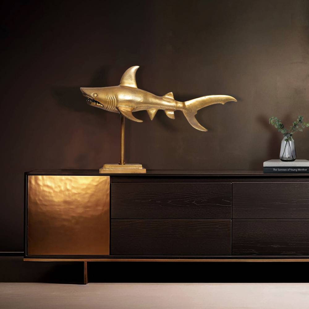 Goldener Haifisch Dekoartikel auf einem dunklen Sideboard im Wohnzimmer oder Büro – Estang