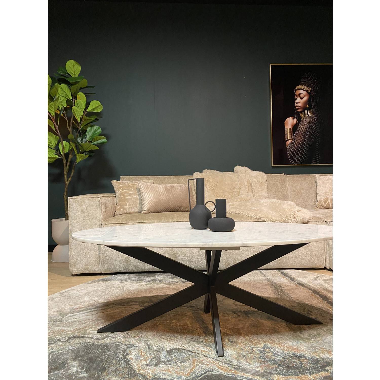 Ovaler Couchtisch mit heller Naturstein-Tischplatte und schwarzem Design-Untergestell für den Wohnbereich – Chamber