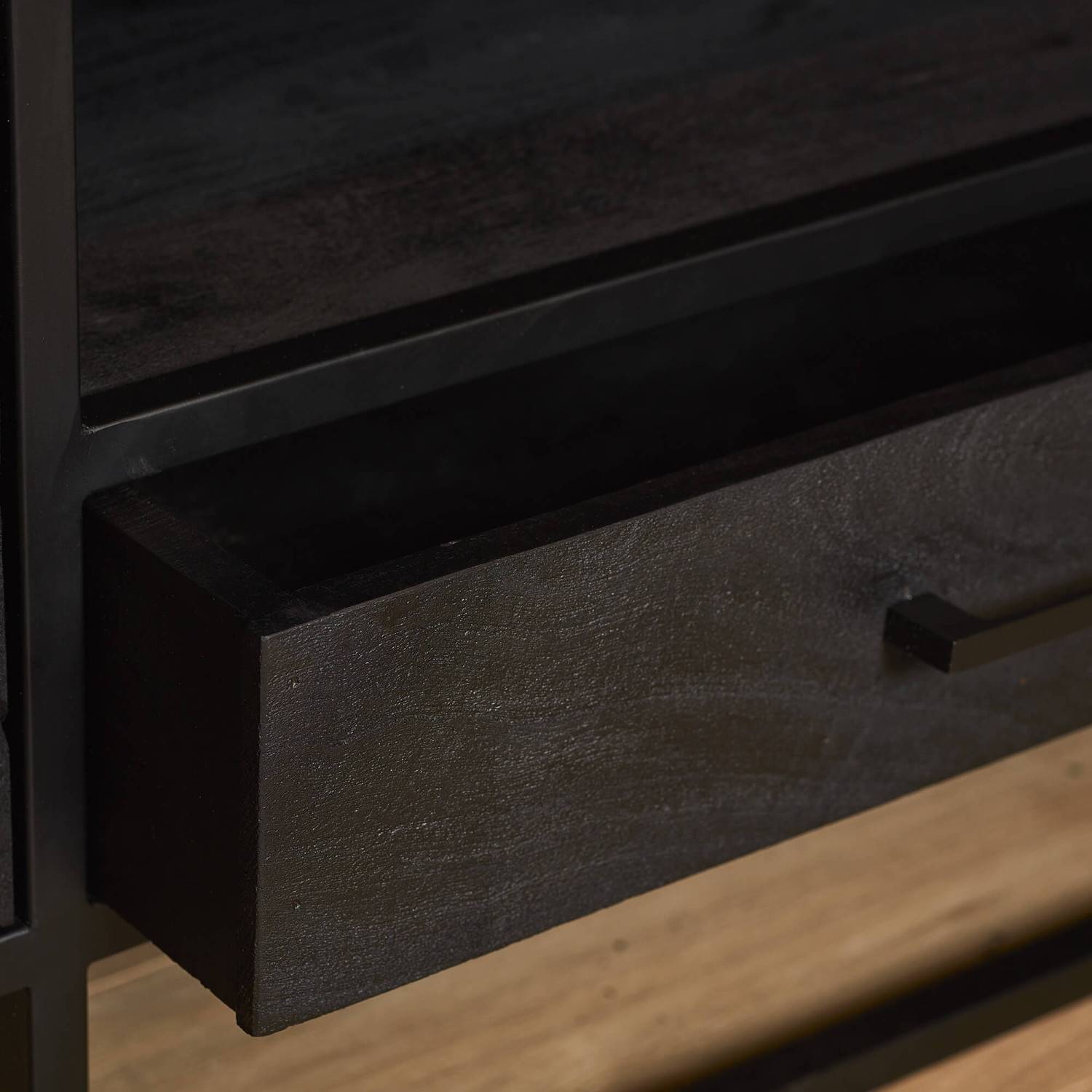 Geöffnete Schublade des schwarzen TV Boards aus Mangoholz mit Griff und Stauraum – Lida