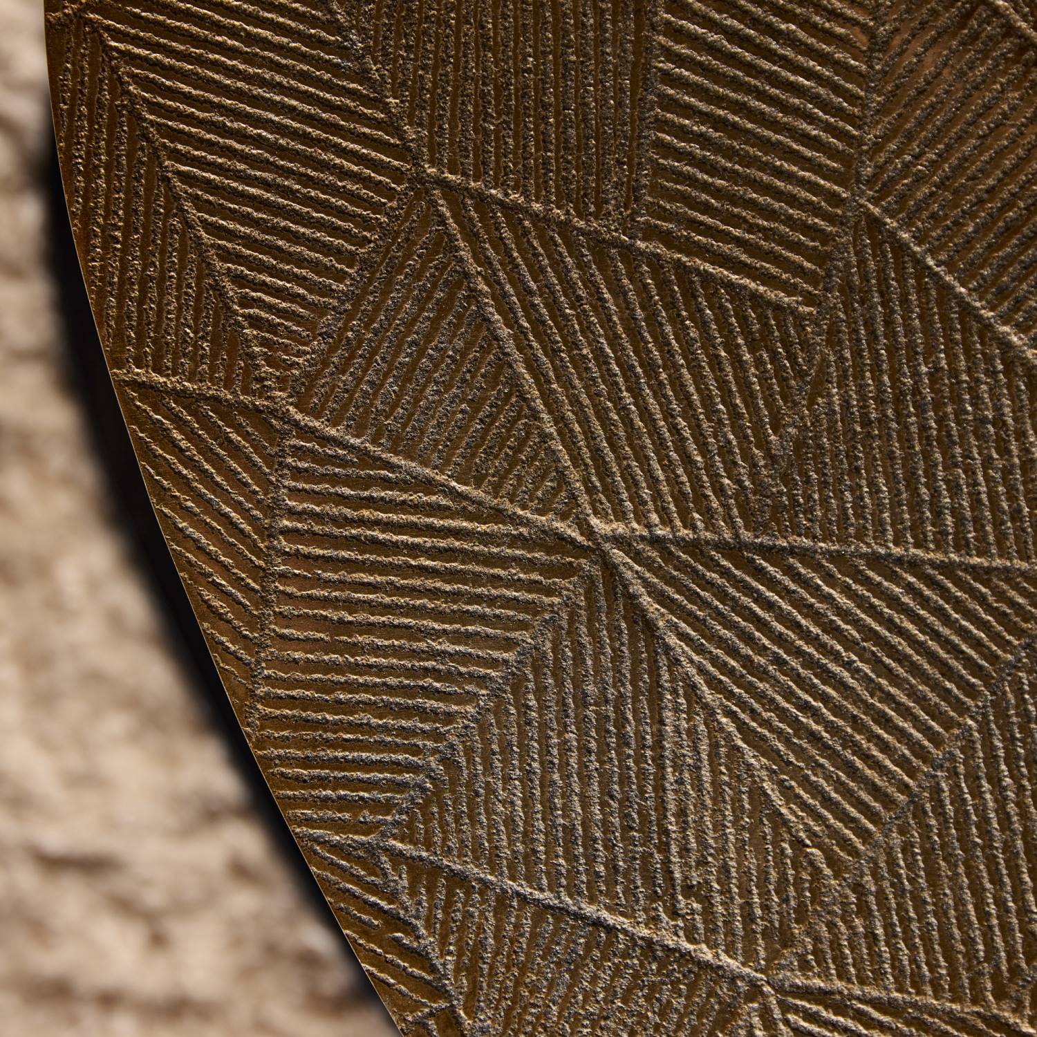 Goldfarbene Tischplatte mit markantem geometrischem Reliefmuster in Nahaufnahme – Calamas