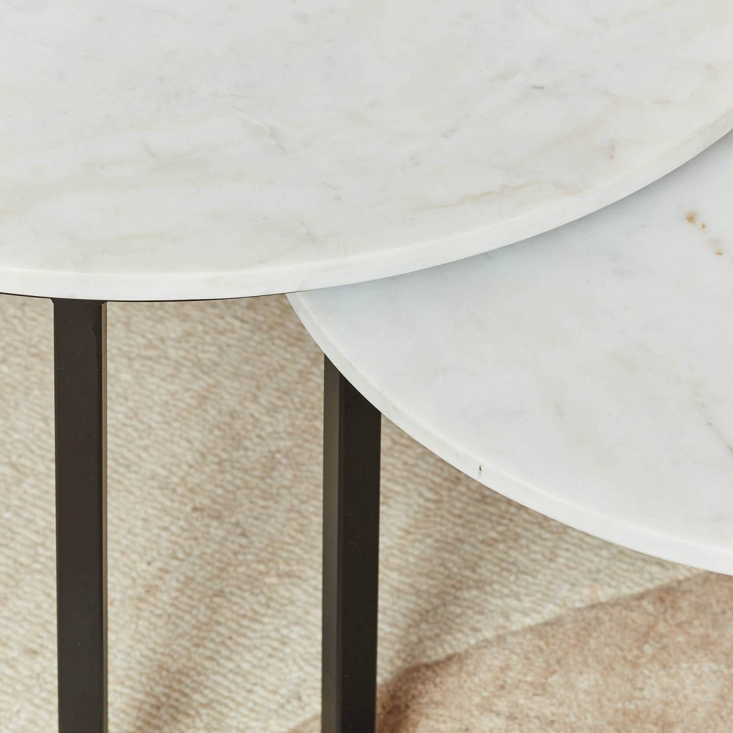 Zwei weiße Marmor-Couchtische mit schwarzen Metallgestellen im Detail – Krispan