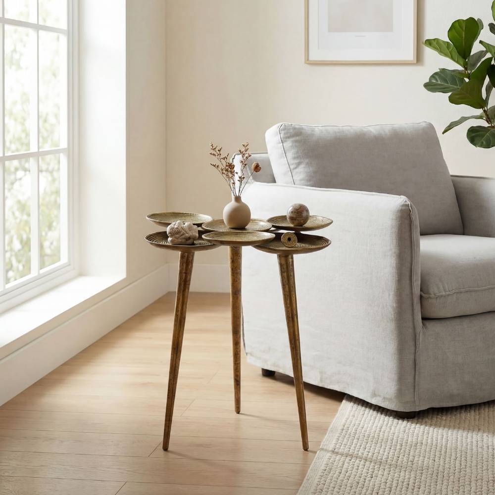 Goldener Beistelltisch mit sechs Ablageschalen neben hellem Sofa im Wohnbereich – Mezzo