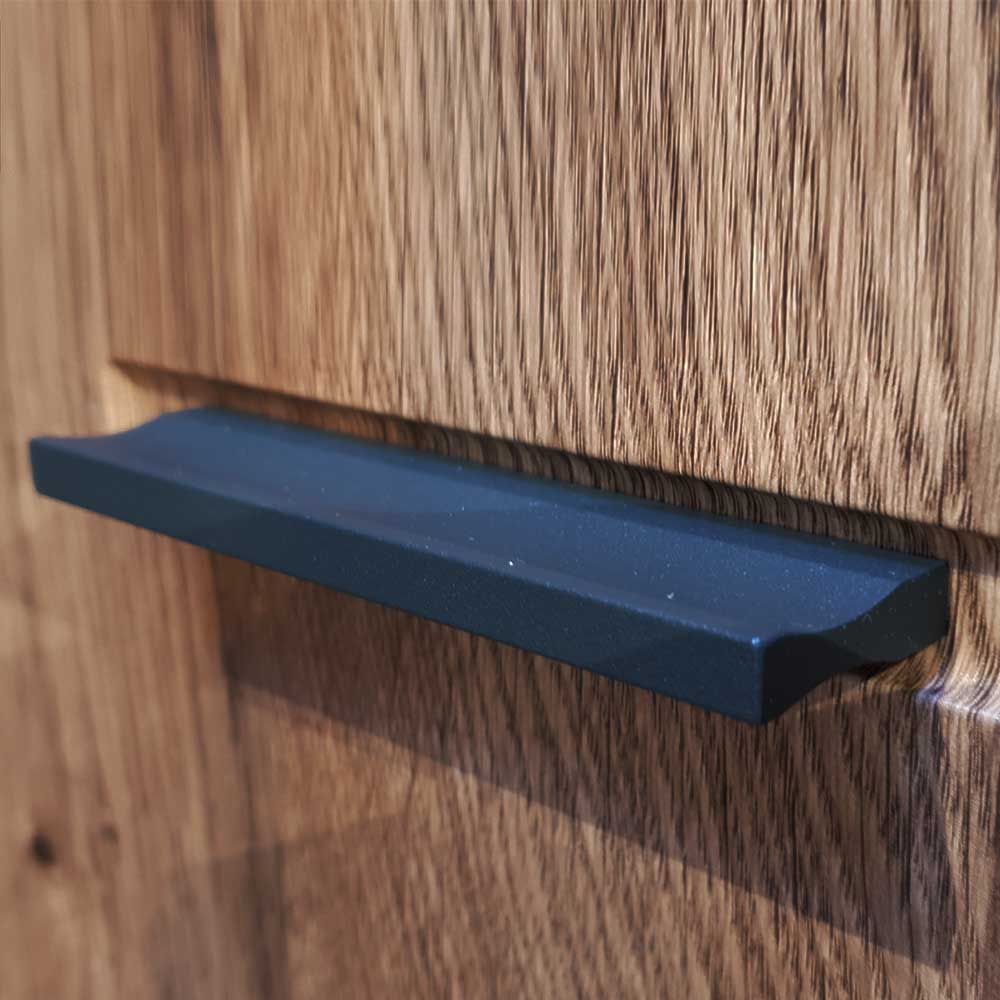 Eleganter schwarzer Griff an einer Schublade oder Tür mit markanter Holzstruktur – Xindus