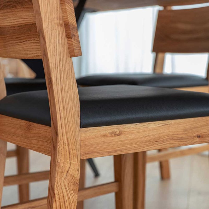 design-holzstuhl-massiv-mit-kunstleder-sitz-in-schwarz-aus-wildeiche